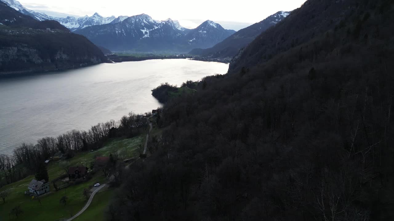 瑞士瓦伦泽雾气朦胧，大气缭绕，鸟瞰山区地形，露出下面宁静的湖泊。地平线上白雪覆盖的山峰。视频素材