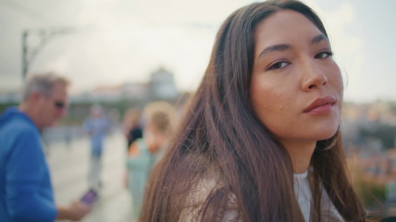 美丽的女孩的脸摆姿势城市看相机肖像。梦想的女人阳光明媚的日子视频素材