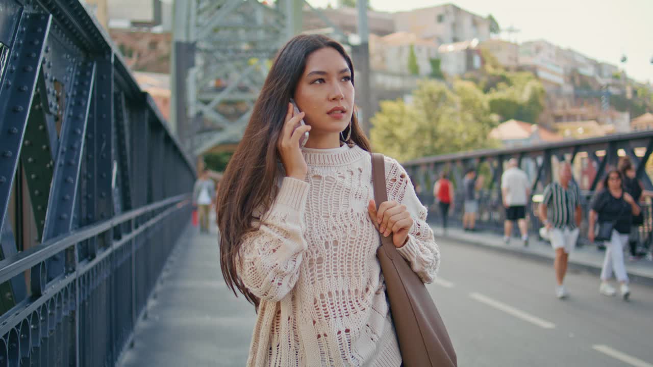 忙碌的女士打电话，走在桥上的特写。女士电话视频素材