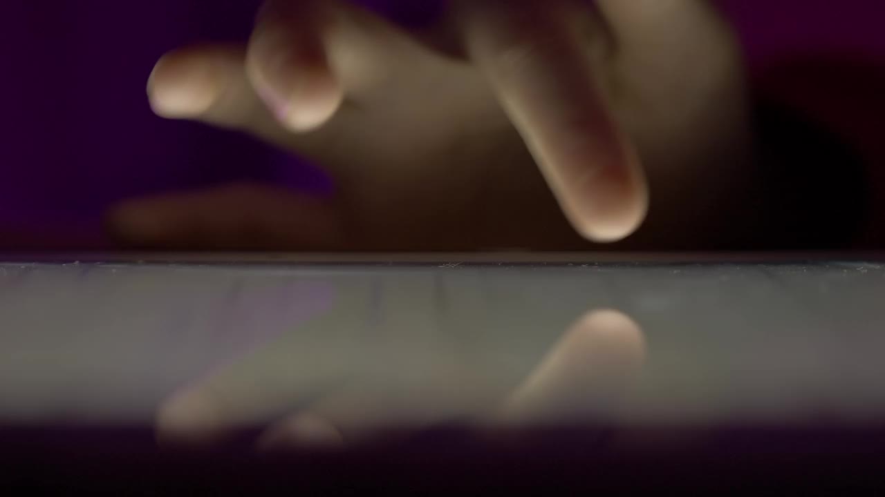 女孩在晚上用手指浏览数码平板电脑。使用智能手机，浏览社交网络的人。近距离手指滚动社交媒体应用程序或阅读新闻动态在线。视频素材