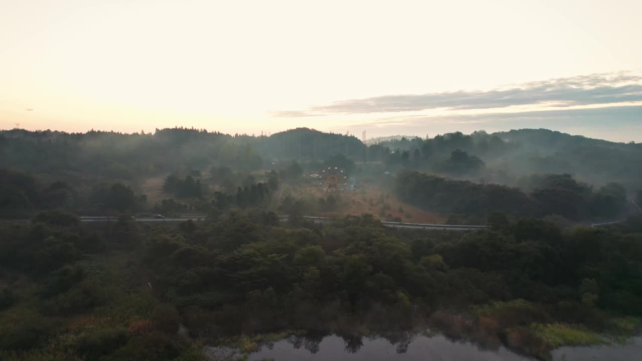 空中全景的游乐园景观摩天轮遗弃在kejonuma休闲岛日本日本郊区乡村山背景日落天际线视频素材