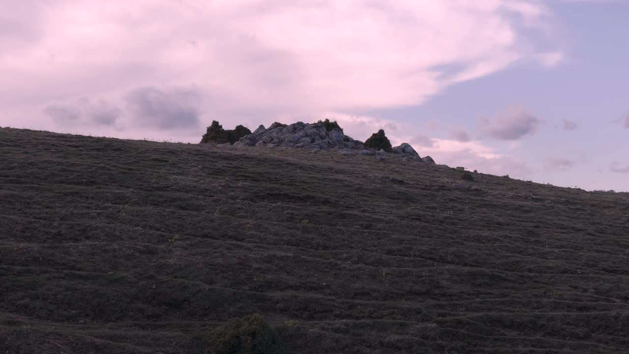 日出时，无人机飞过岩石，露出远处的雪山。视频素材