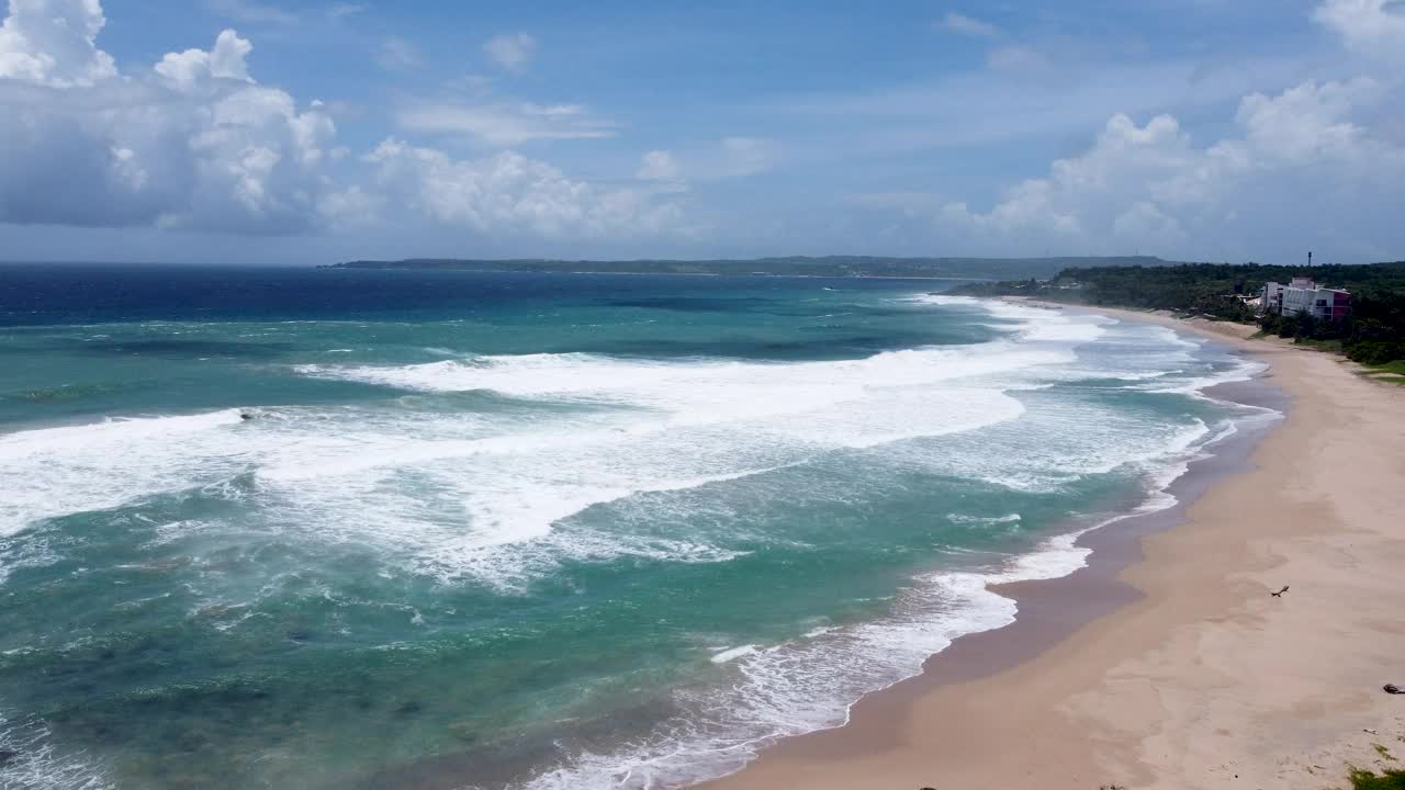 一个充满活力的海滩，绿松石色的海浪拍打着，阳光明媚的日子，鸟瞰图视频素材