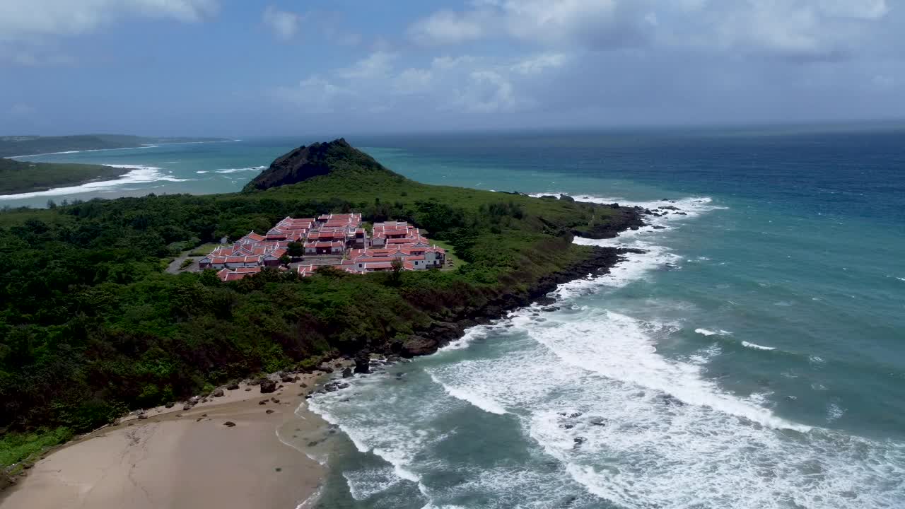 海岸度假胜地的海角与冲击的海浪，阳光明媚，有一些云，鸟瞰视频素材