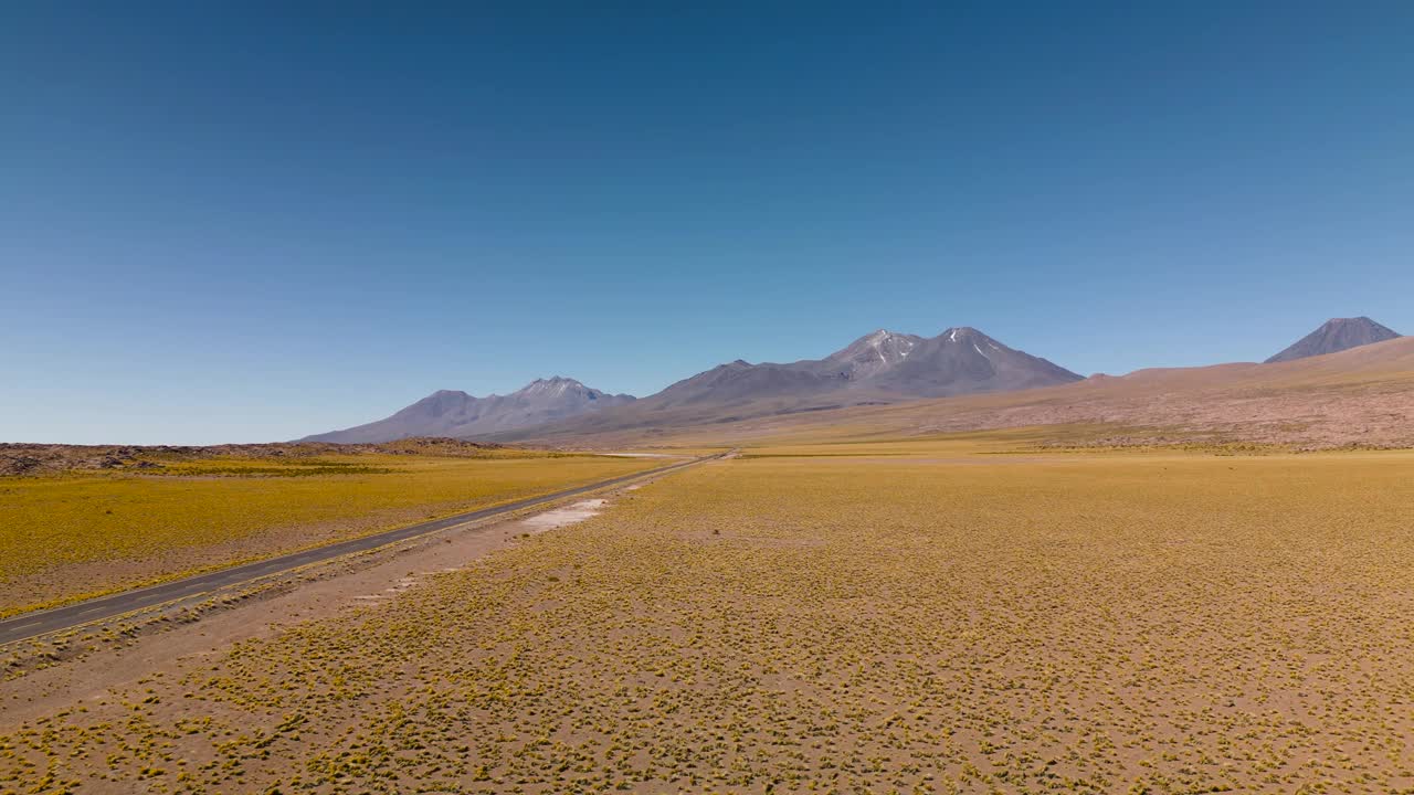 在晴朗的蓝天下，一条穿越智利广阔而宁静的高原的沙漠公路视频素材