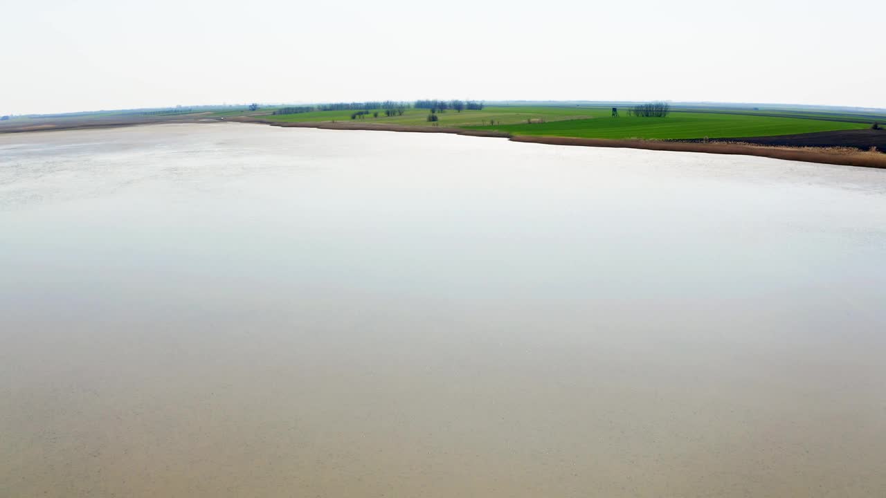 美丽的视频由无人机在干涸的湖泊上向绿色的海岸飞行视频素材