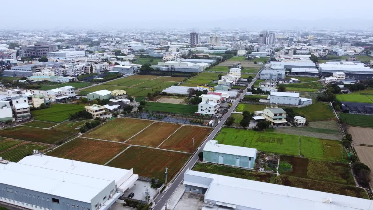 一个多样化的城市景观过渡到农田，在阴天，鸟瞰图视频素材