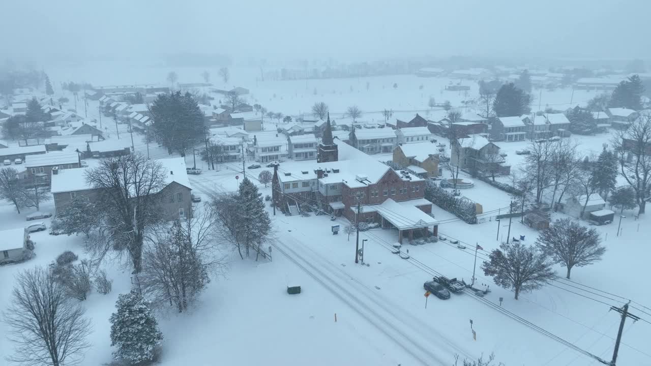 暴风雪期间的美国小镇。大雪期间的教堂和房屋。冬季架空。视频素材