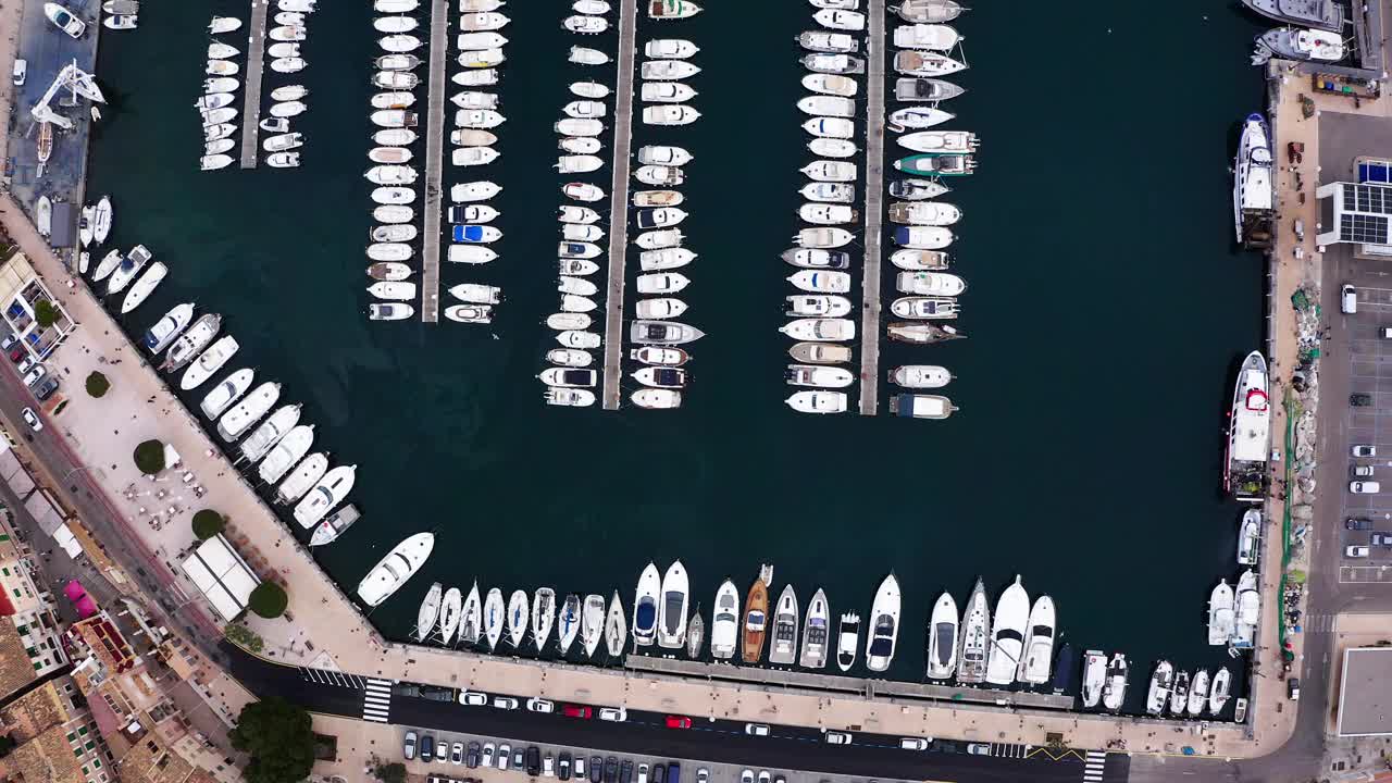 令人惊叹的飞行无人机地中海海港的航拍视角，在熙攘的码头码头，港口de Sóller，巴利阿里群岛，西班牙马略卡岛，满溢着宏伟的豪华游艇视频素材