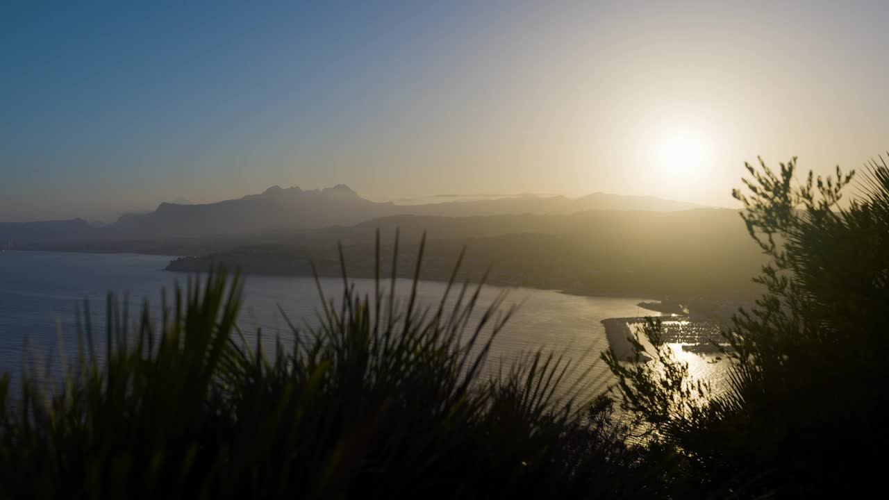 从高处俯瞰西班牙海岸和山脉，欣赏五彩缤纷的夏日日落视频素材