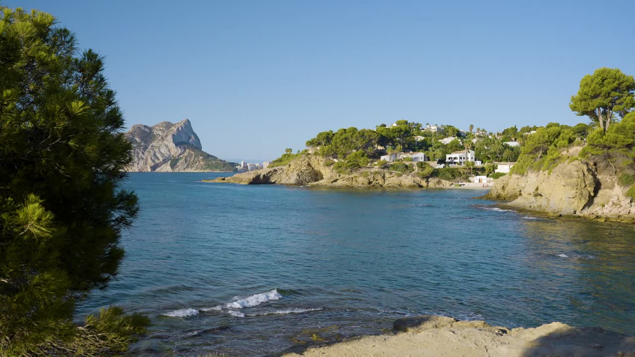 西班牙地中海沿岸温暖的夏日早晨，游客沿着美丽的岩石海岸度假视频素材