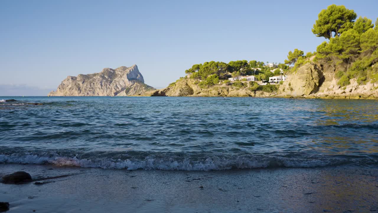 在夏季旅游度假季节，海浪轻轻地拍打着西班牙海岸线上安静的海湾视频下载