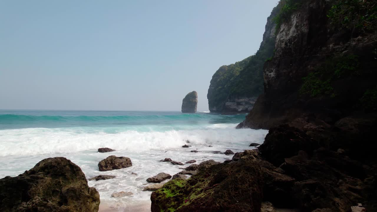 夏天，在印度尼西亚巴厘岛的努沙佩尼达，浪花飞溅在崎岖的海岸上。无人机拍摄的视频素材