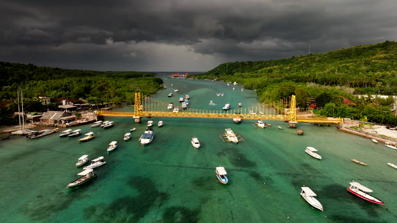 漂浮在巴厘岛海上的船只，印尼努沙莱姆邦根岛和塞宁安岛之间的黄桥。-航拍视频素材