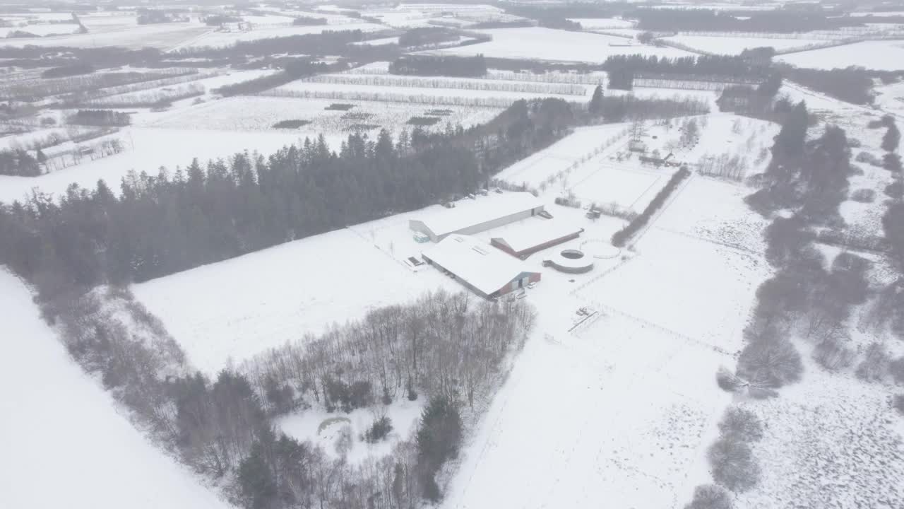 鸟瞰冬日雪景中的乡村马场。视频素材