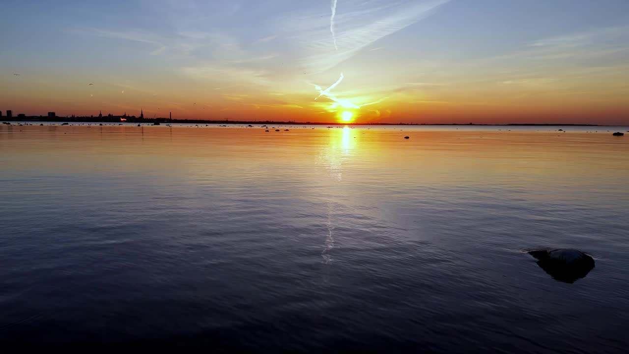 波罗的海塔林湾宁静的日落景象，画面中央有一块岩石突出，向右倾斜视频素材