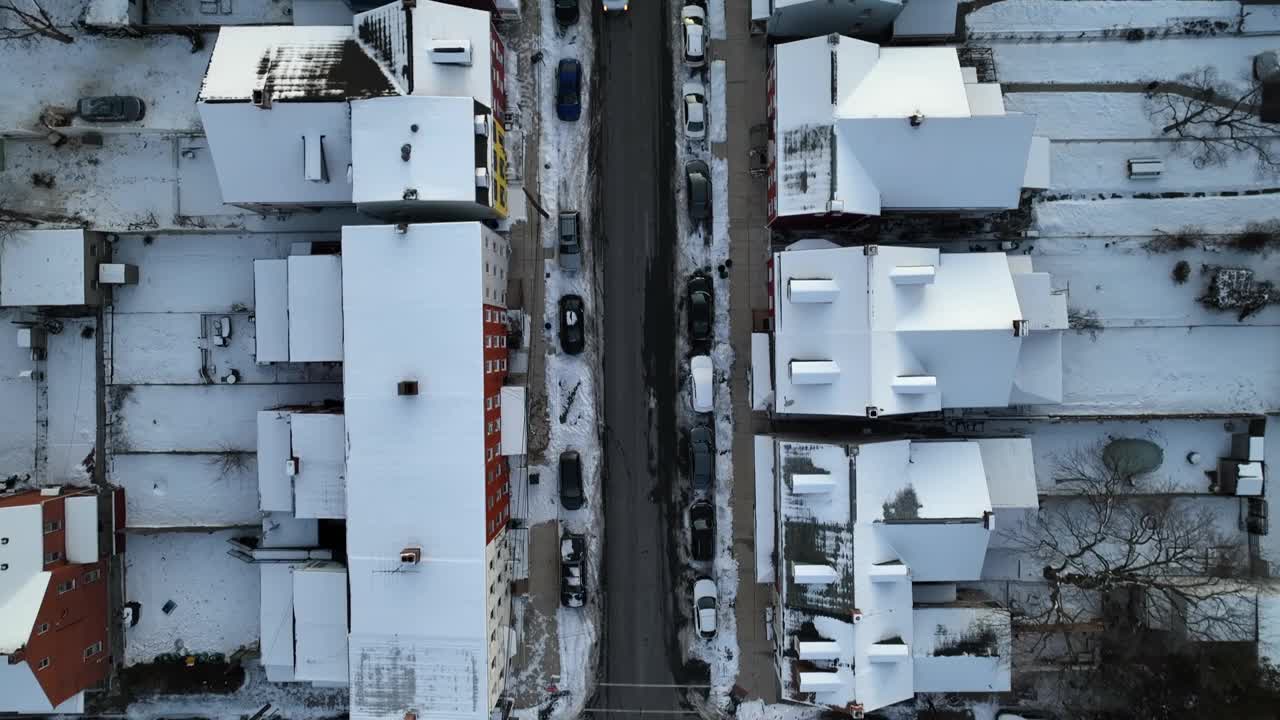 在下雪的冬日里，美国城镇主要街道上的交通。小镇的圣诞节。白雪覆盖了房屋和家庭。鸟瞰图。视频素材