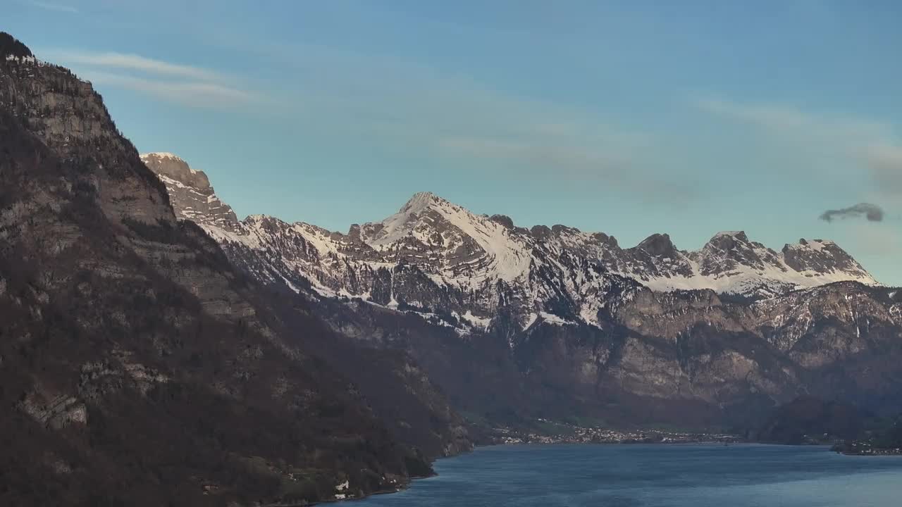 丘尔弗斯滕山脉的雪峰高耸在瓦伦泽湖之上。雄壮的自然鸟瞰图从无人机。居住在圣加仑州的小村庄和人们。瑞士视频素材