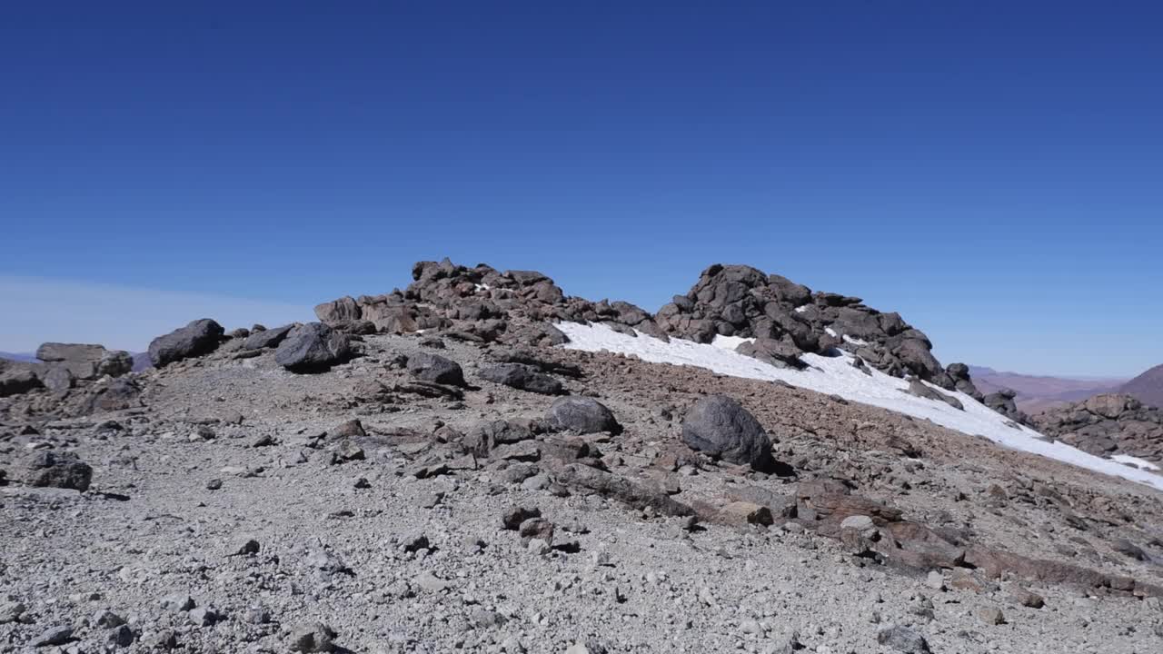 在寒冷的蓝天里，徒步旅行者走在遥远的落基山山顶上视频素材