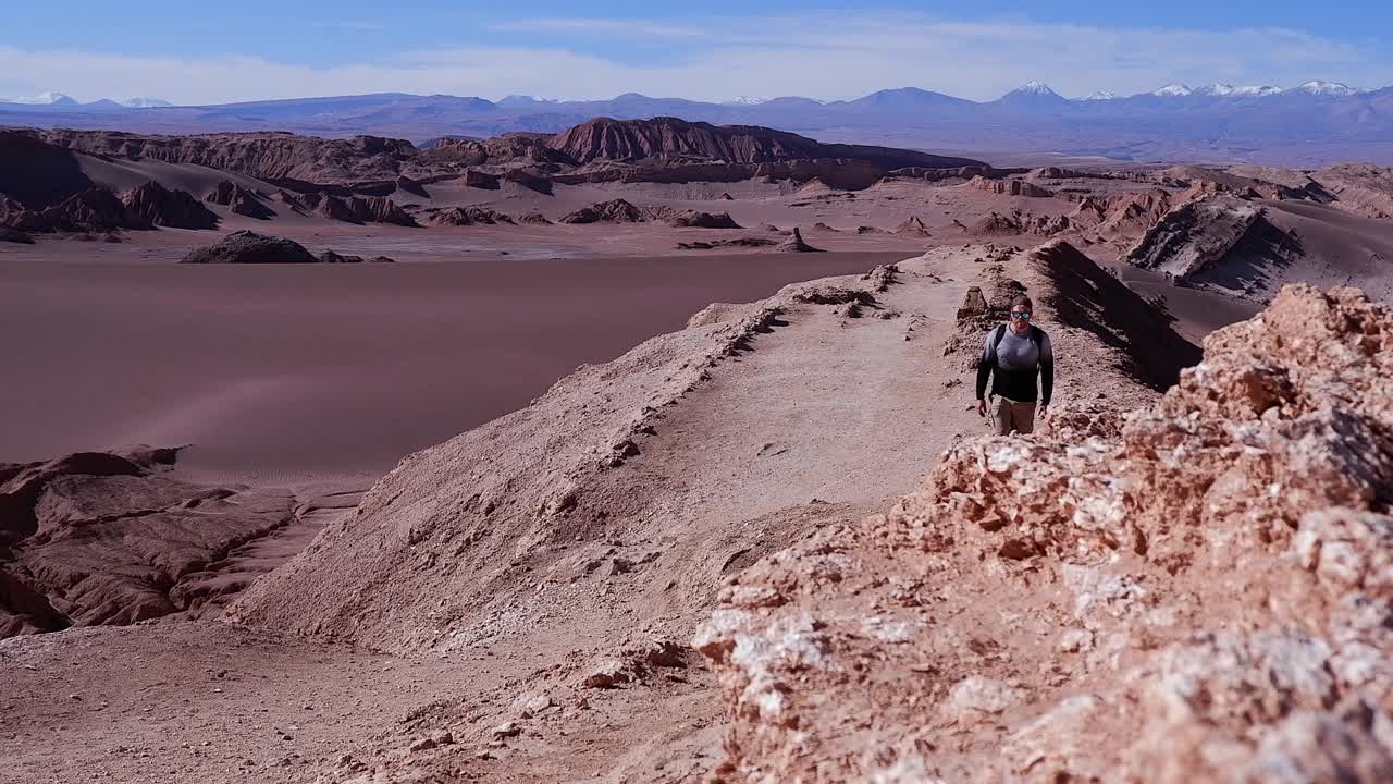 一个人沿着智利阿塔卡马沙漠的砾石山脊徒步旅行视频素材