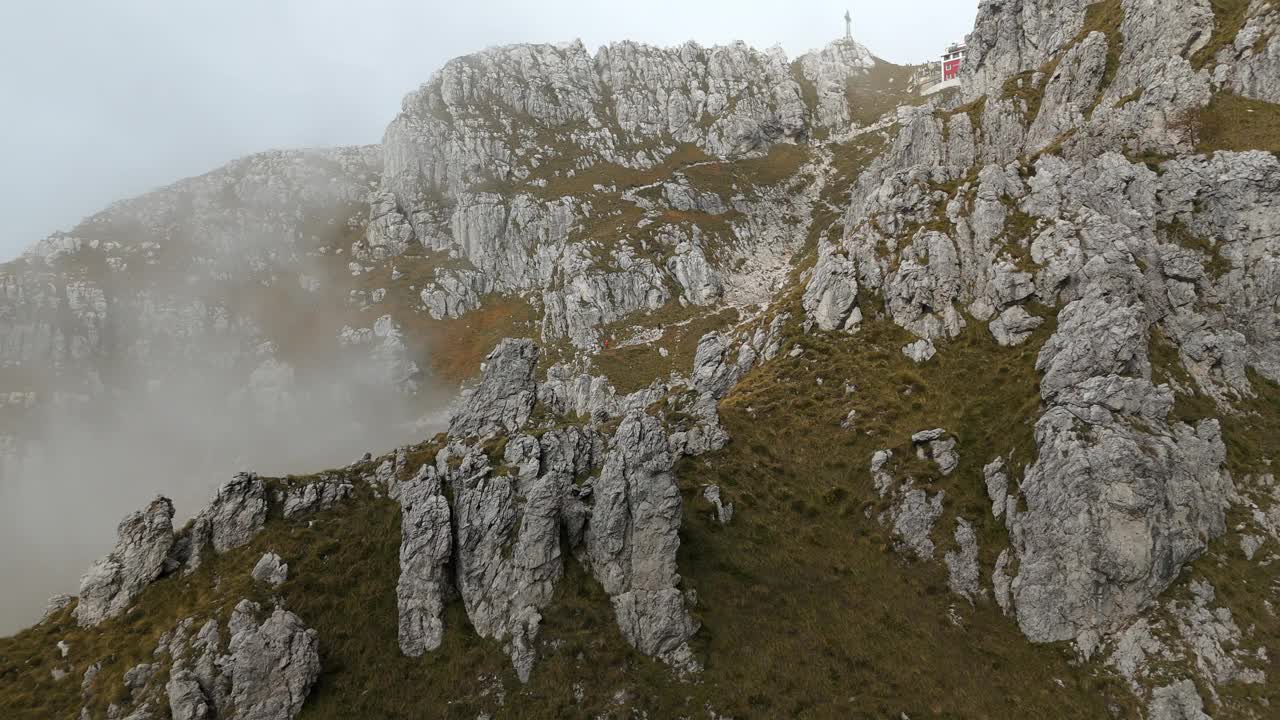 徒步旅行者在浓雾中攀登意大利北部的雷塞戈内落基山脉。航拍无人机前视视频素材