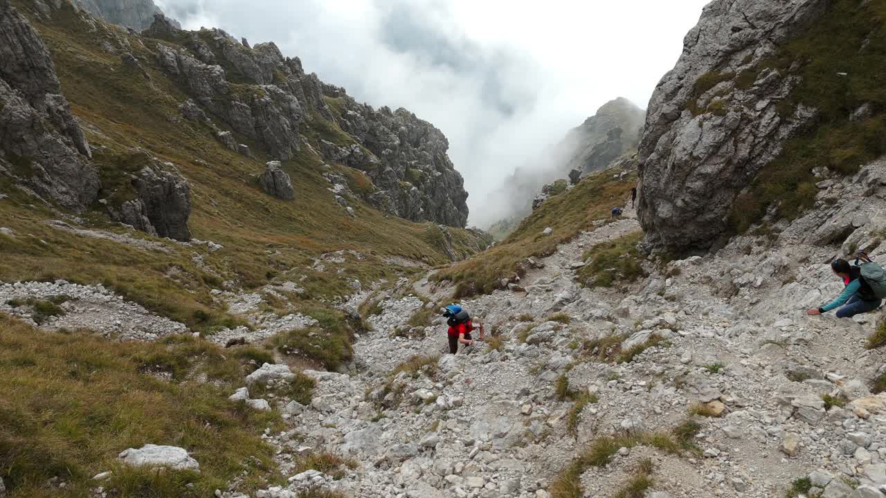 静态视图徒步旅行者攀登雷塞戈内岩石山在意大利北部的云为背景视频素材