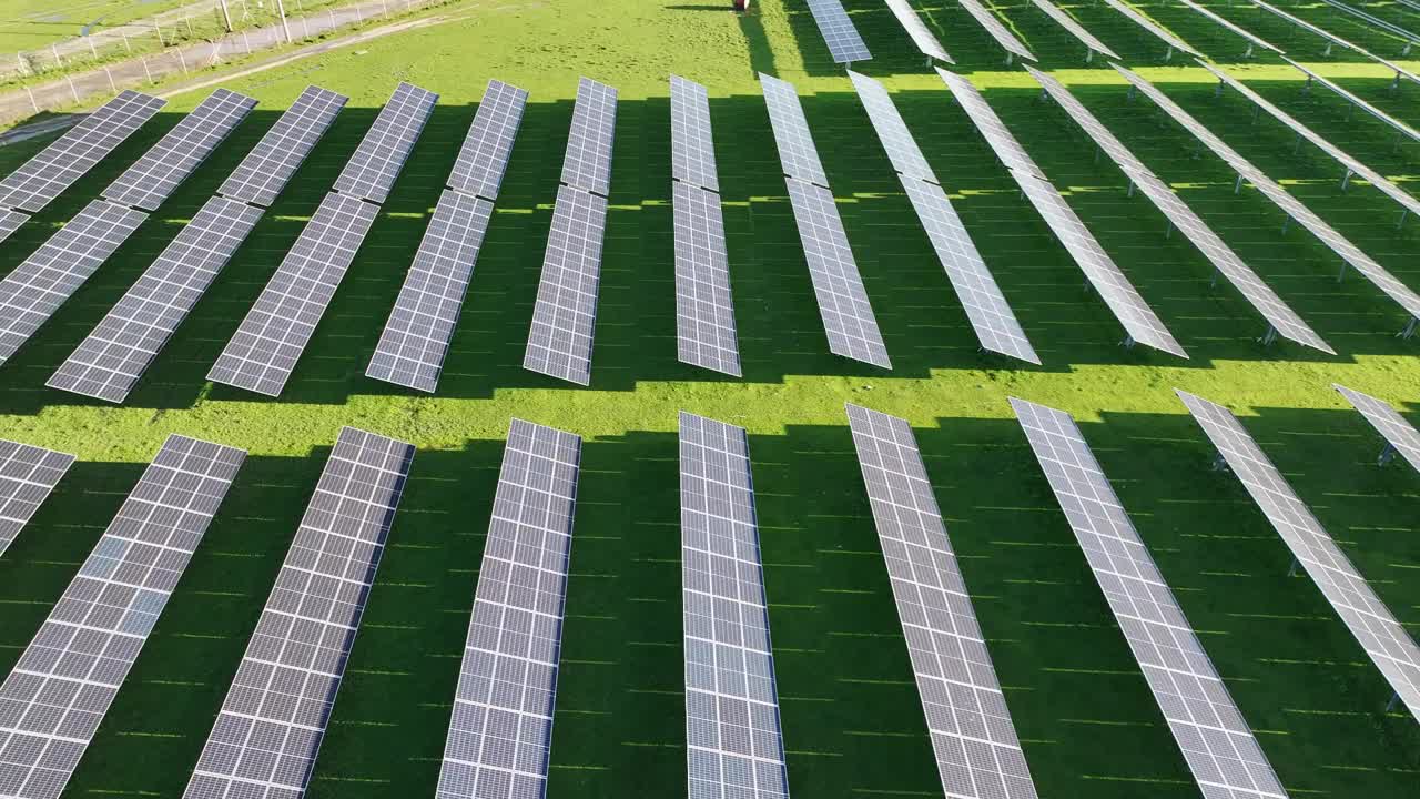 新太阳能农场的俯视图。绿野旁边一排排现代的光伏太阳能板。视频下载