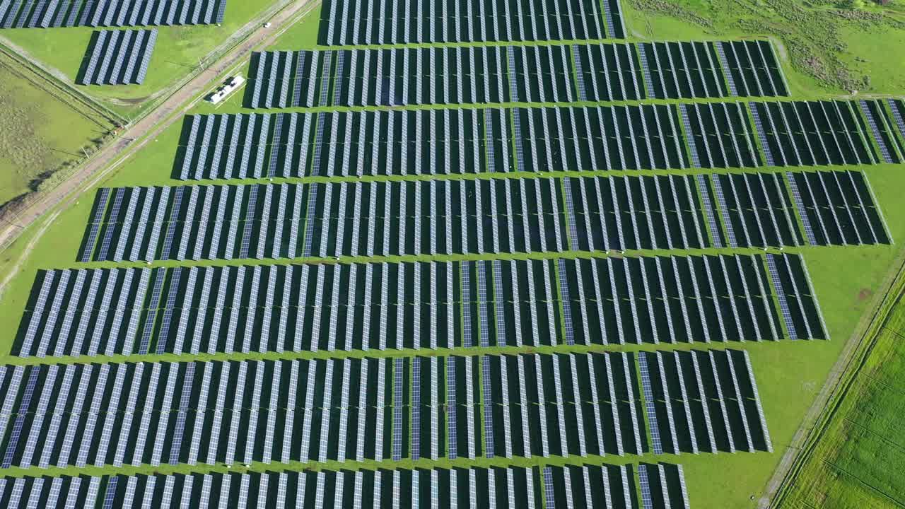 新太阳能农场的俯视图。绿野旁边一排排现代的光伏太阳能板。视频下载