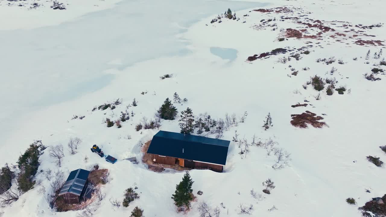 鸟瞰冬天被厚厚的雪包围的山间小屋。视频素材