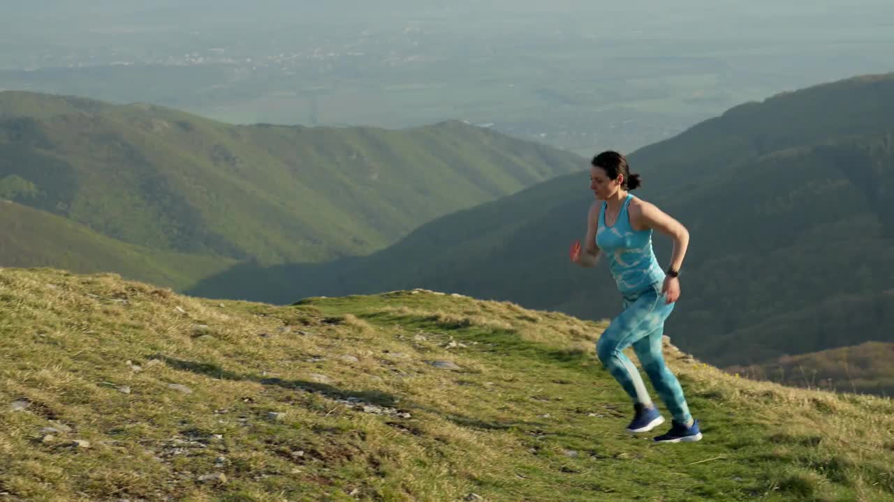 4K视频的女子运动员越野跑跑步和攀登山崖在她的训练。极端的地形。视频下载