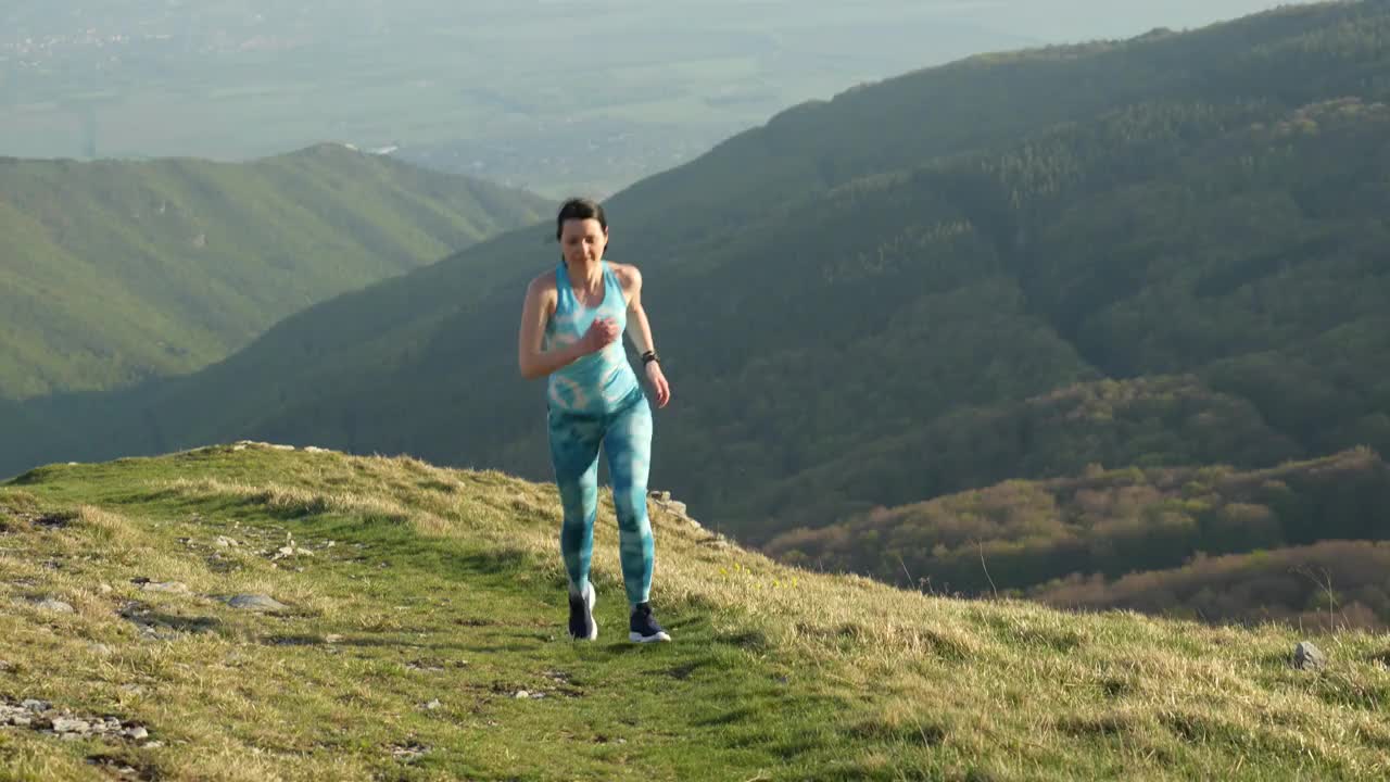 4K视频的女子运动员越野跑跑步和攀登山崖在她的训练。极端的地形。视频素材