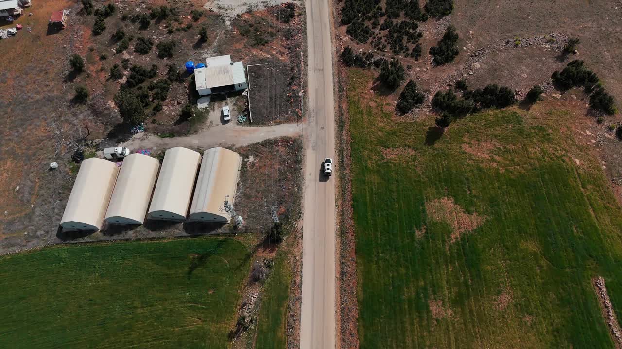 航拍的车辆行驶在沥青道路在农村地区视频素材