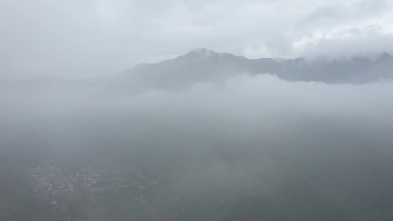 无人机在浓雾笼罩的山村上空飞行视频素材