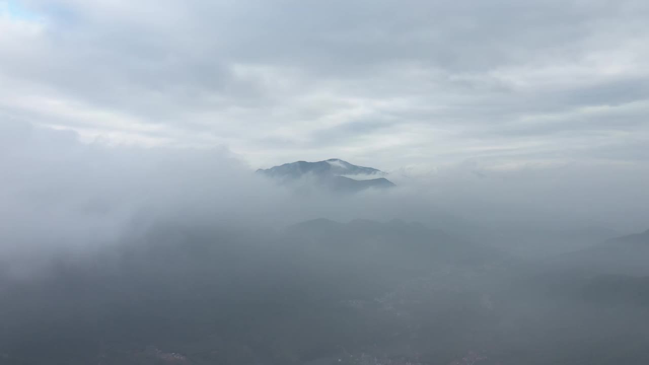 无人机在浓雾笼罩的山村上空飞行视频素材