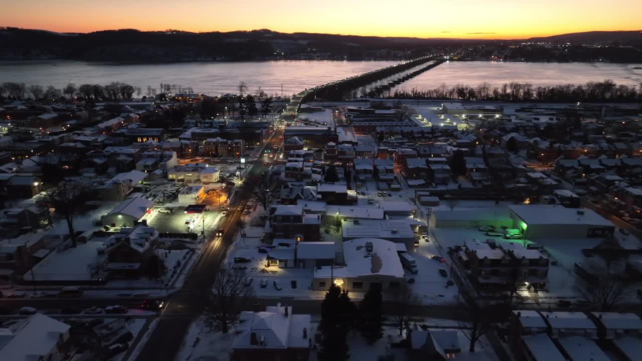 美妙的照明城市哥伦比亚在冬季雪在黄金时间。美国兰开斯特，积雪覆盖的屋顶。晚上的萨斯奎哈纳河和大桥。横向航拍广角镜头。视频素材