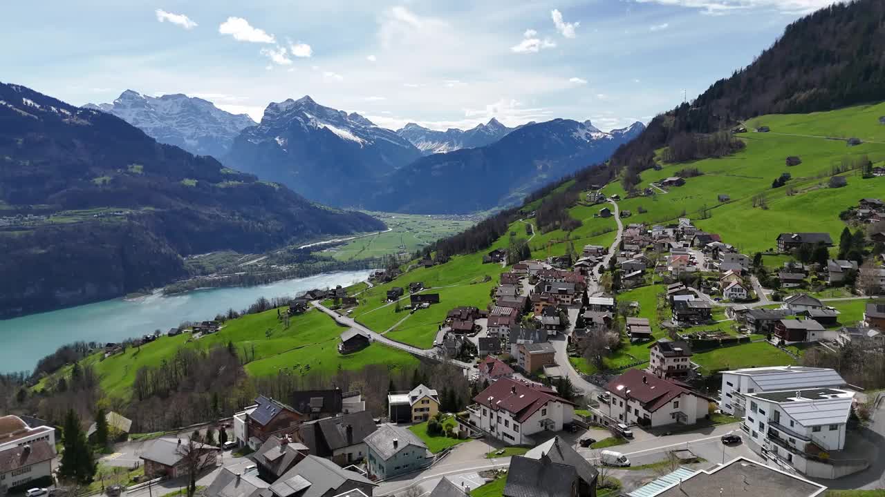 古雅的瑞士风景，山上有建筑和房屋。绿松石般的瓦伦湖和白雪皑皑的山峰。航拍全景镜头。视频素材