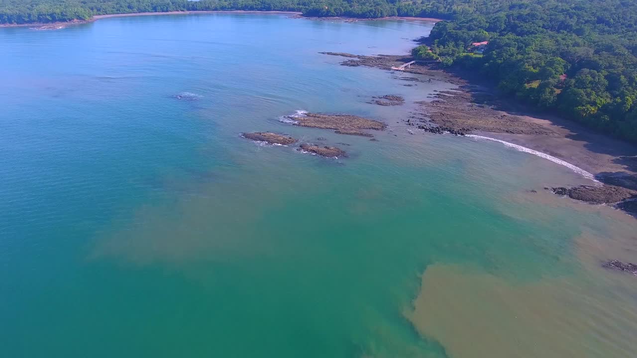 在巴拿马群岛的一个空旷的日子里，飞机飞过沿着海岸旋转的脏水视频素材