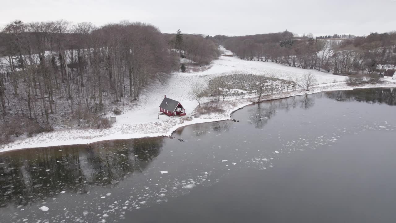 航拍的红色北欧小屋在冰冻的峡湾海岸视频素材