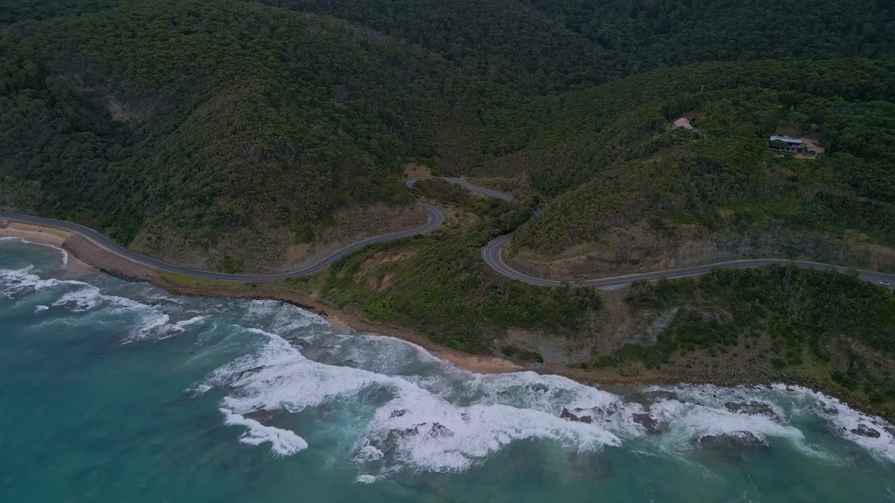 澳大利亚的大洋路轨道无人机拍摄的维多利亚州弯曲的高速公路和撞击海岸的海浪视频素材