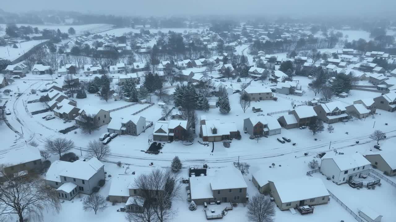 冬季被雪覆盖的住宅开发高架图。无人机在美国社区上空拍摄。视频素材