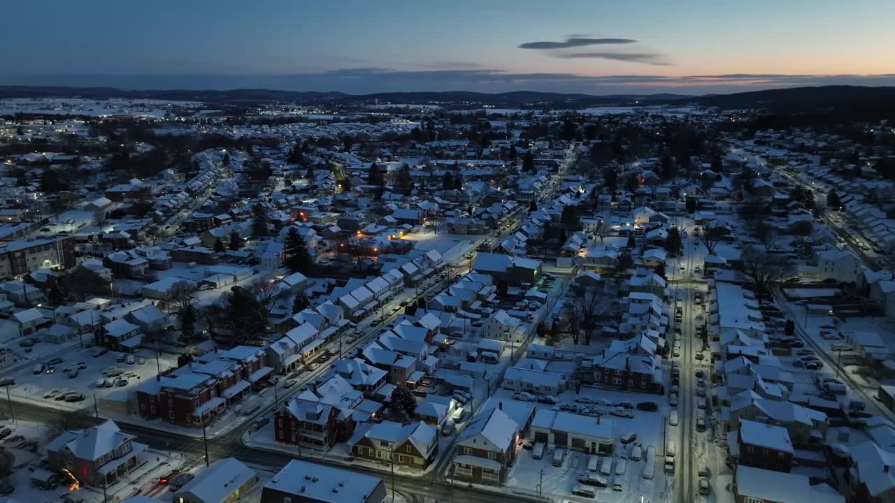 美国小镇在黎明时分被雪覆盖。冬季积雪房屋的高空拍摄。视频素材