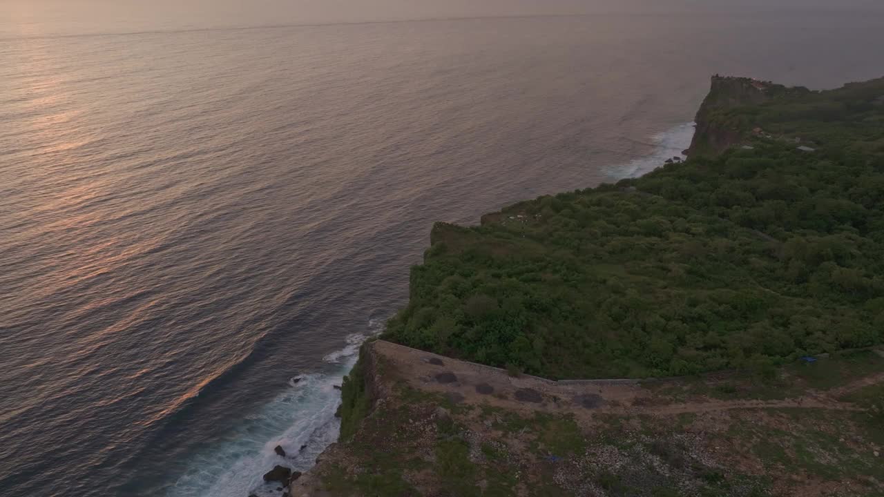 鸟瞰悬崖边的海滩在日落俯瞰印度洋，巴厘岛。视频素材