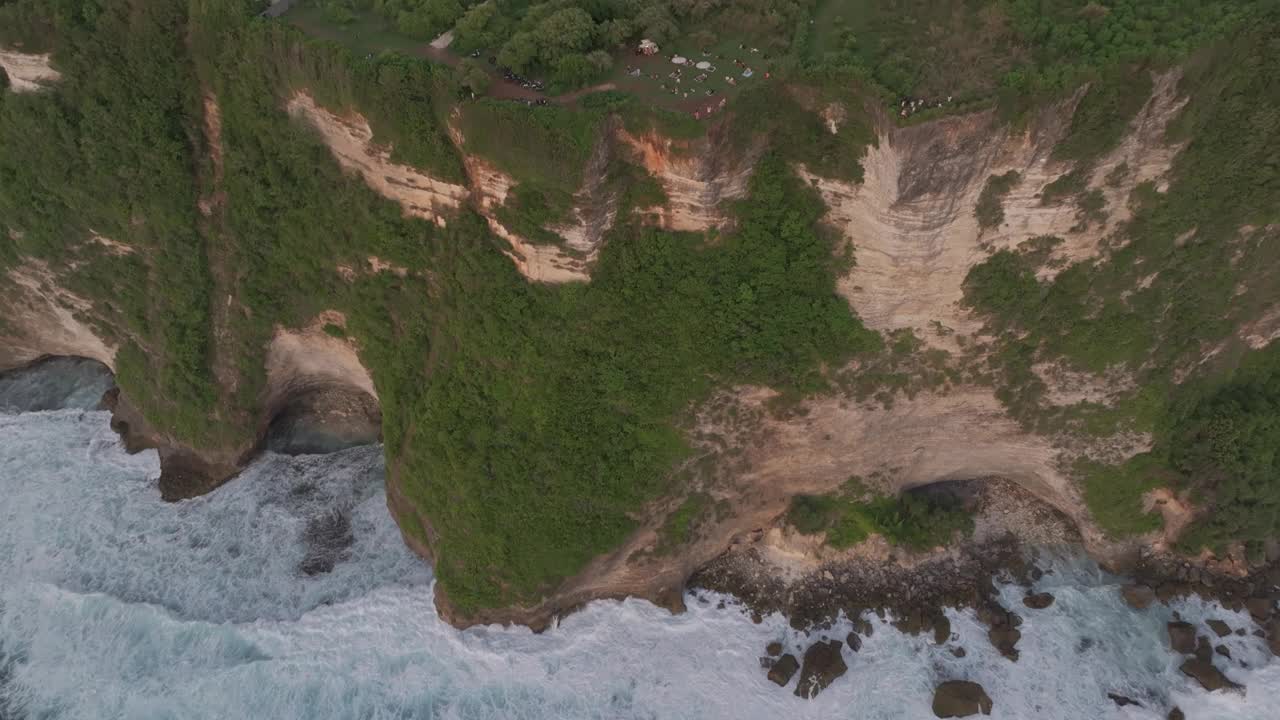 日落时悬崖边海滩的鸟瞰图，巴厘岛。视频素材