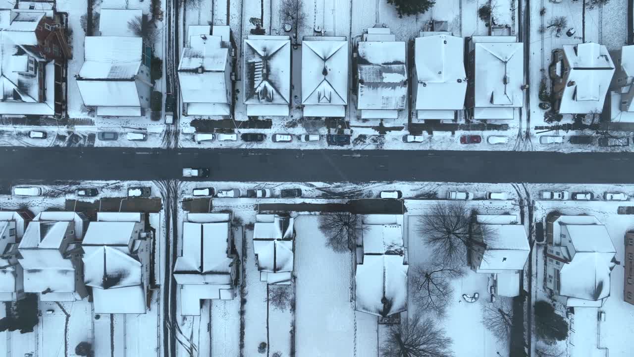 从上到下的航拍，积雪覆盖的城镇房屋和街道。视频素材