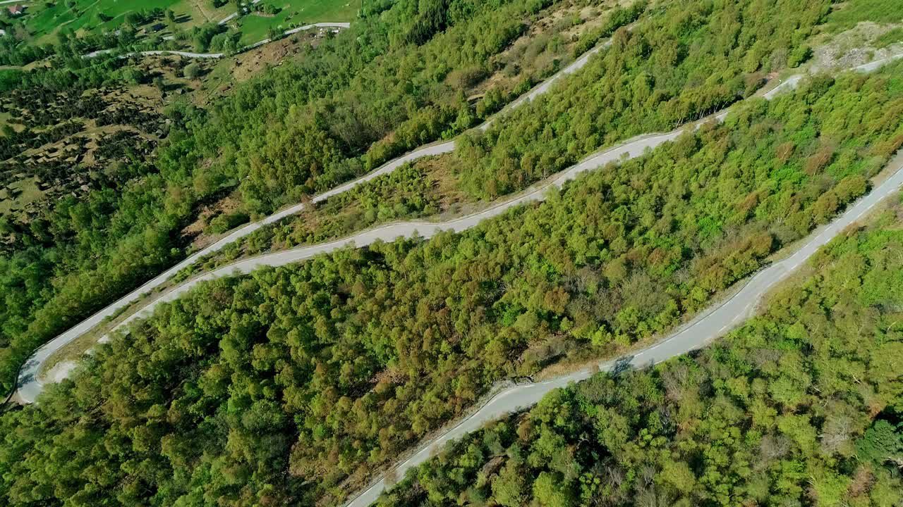 空中弯曲山口公路穿过森林自然景观无人机镜头视频素材