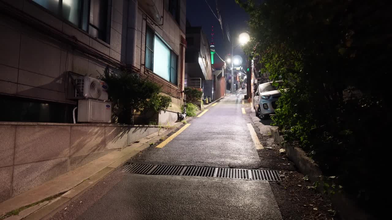 夜晚，沐浴在柔和灯光下的首尔宁静街道。人们漫步在融合了现代和传统的建筑旁，营造出和谐的城市景象。视频素材