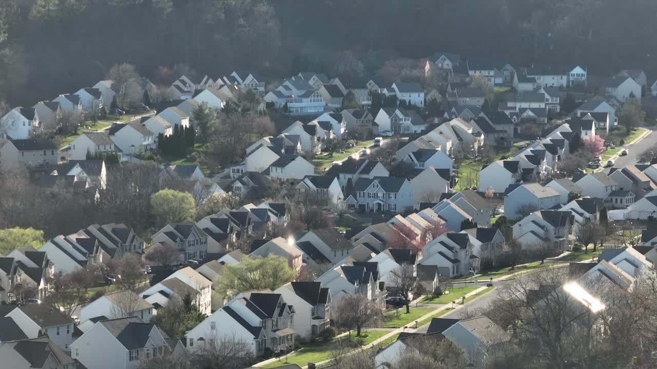 一群黑鸟飞过美国城镇郊区新开发的住宅区。春天晴朗的一天。飞往温暖的南方。航拍变焦广角镜头。视频素材