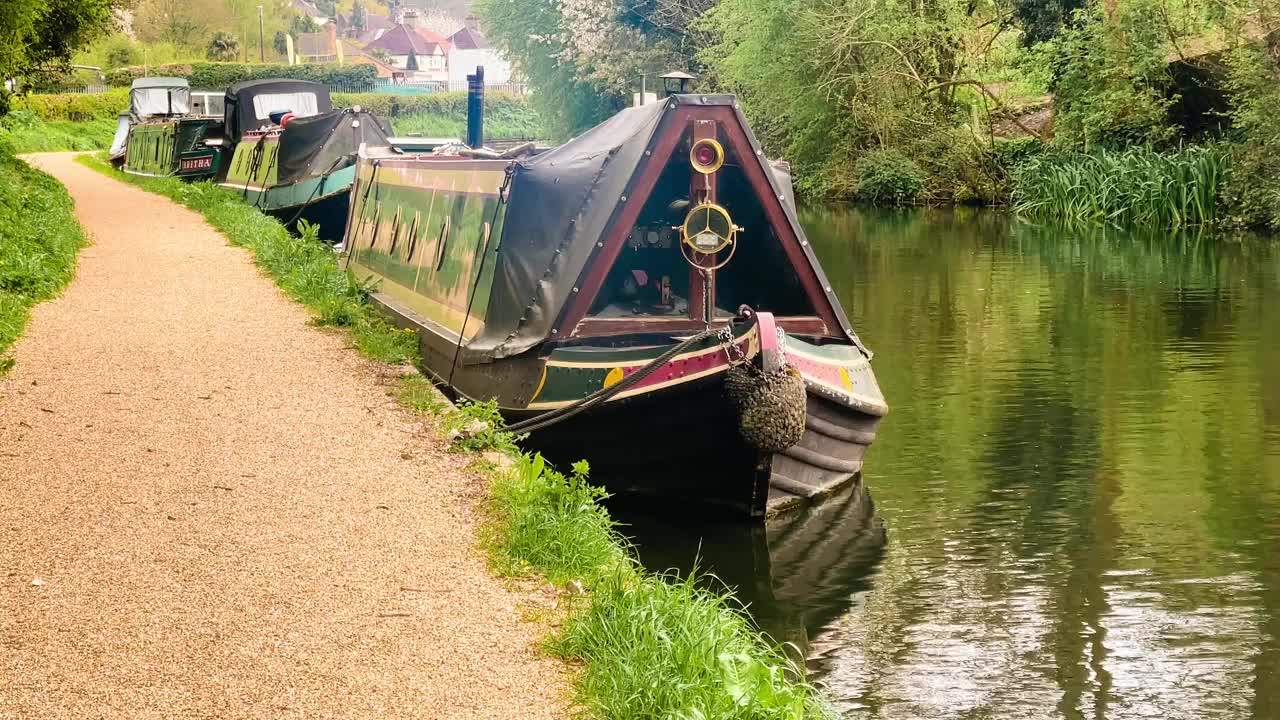 在英国英格兰赫特福德郡阿普斯利，运河船和风景如画的水道被郁郁葱葱的绿色植物和古朴的乡村所包围视频素材