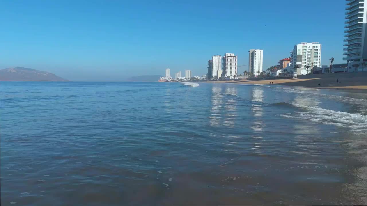 当镜头在马萨特兰宁静的海岸上向后滑动时，一个破碎的海浪将它的薄雾喷向观众，提供了一个宁静而身临其境的海岸体验。视频素材