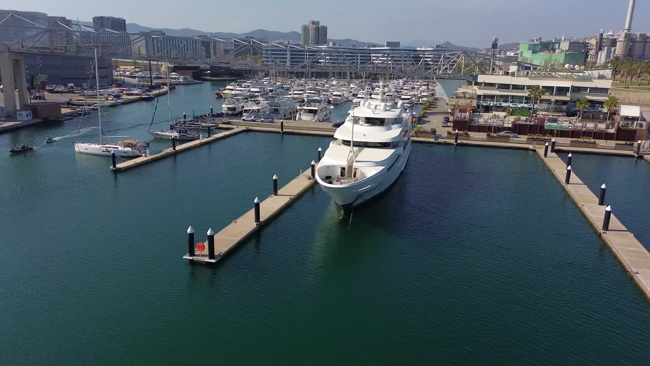 无人机航拍的一艘停泊在巴塞罗那港口的巨型游艇，背景是巴塞罗那视频素材